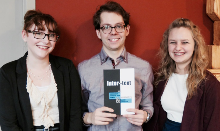 the three founding editors proudly hold up a copy of their newly arrived publication
