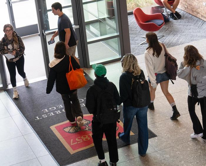 students walking in brown hall foyer