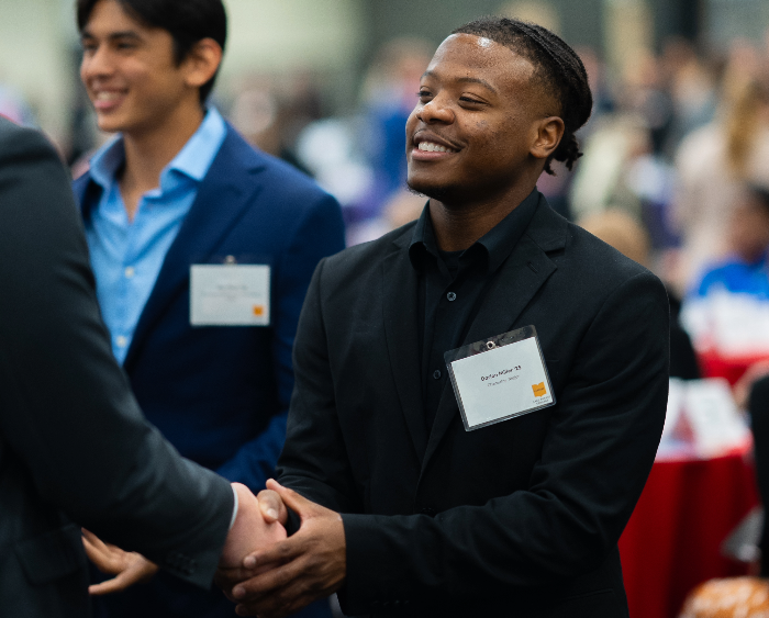 student shaking hands with mentor