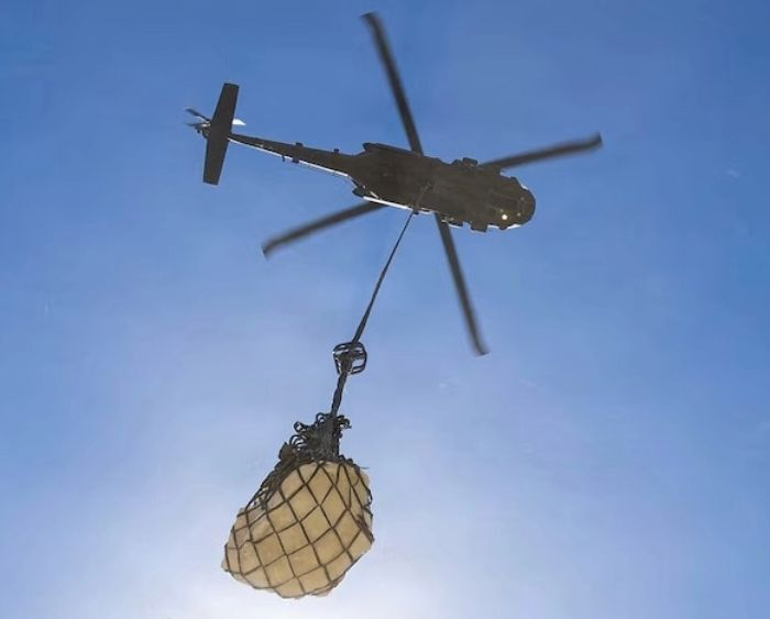 a helicopter lifts a dinosaur fossil
