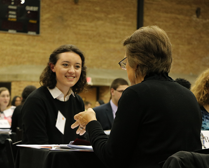 student shaking hands with an employer