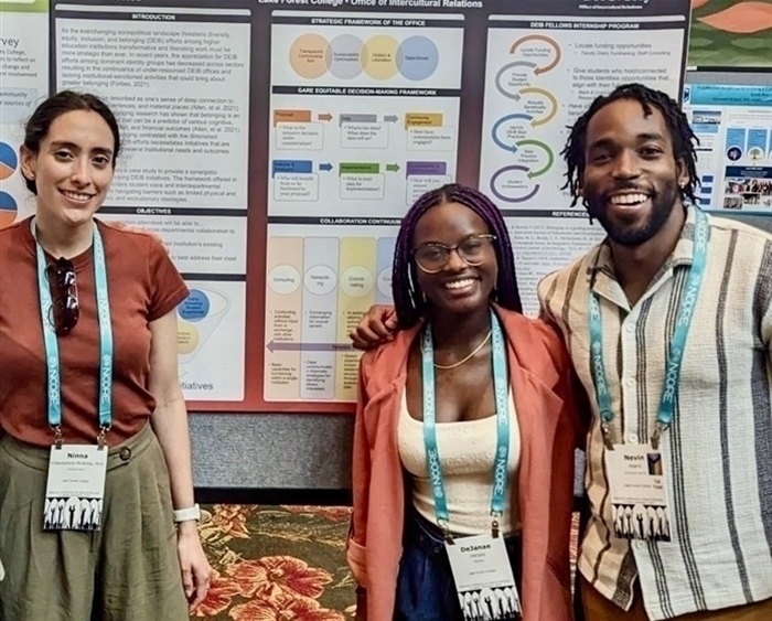 three people in front of presentation poster
