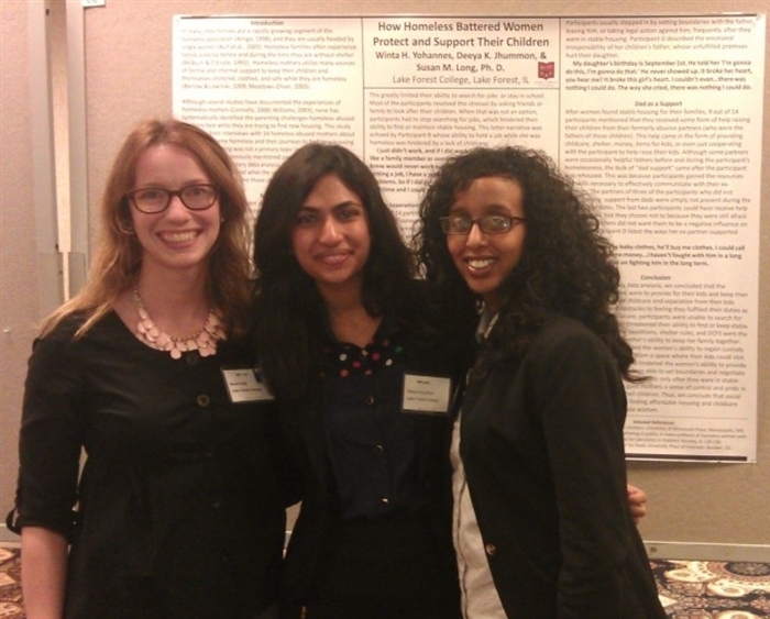 professor and two students with their research poster at conference