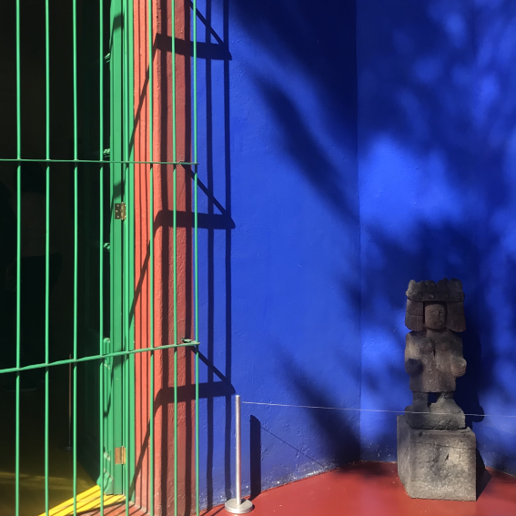 a gate and a statue next to a colorful wall