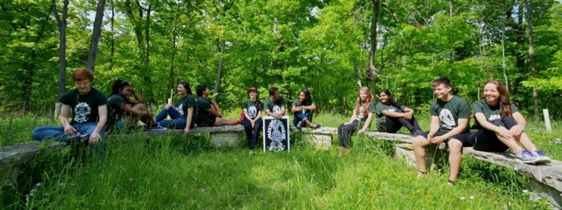 students sitting casually on log benches in prairie